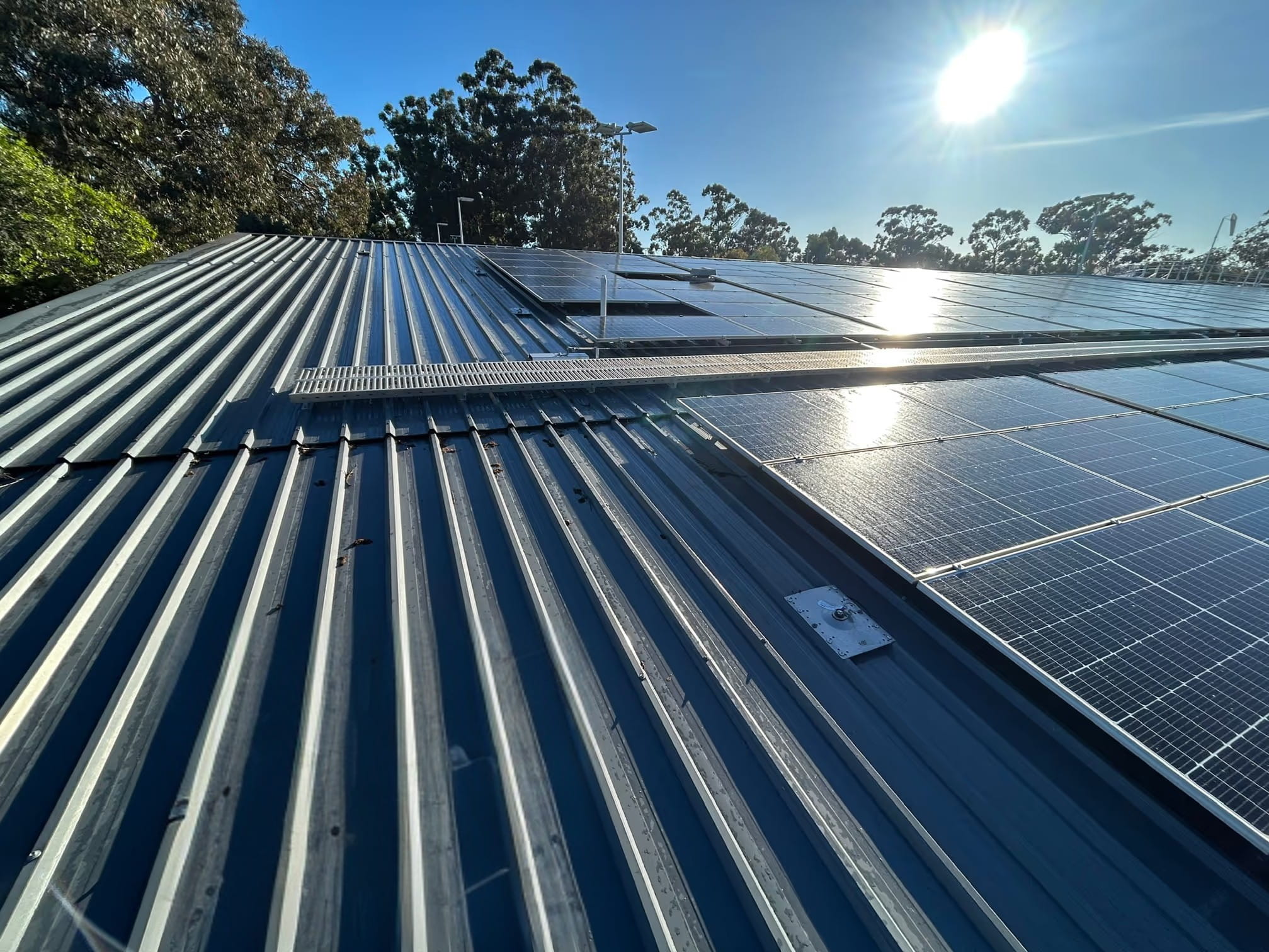 Commercial metal roof with solar panels and rooftop access walkway