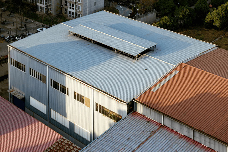 Aerial view of a warehouse with large flat metal roofing system.